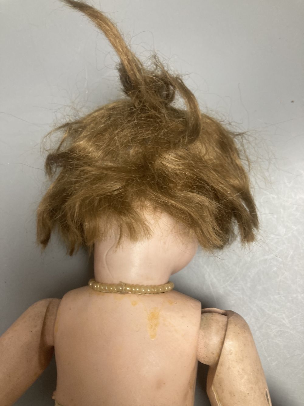An Armand Marseille bisque boy doll, mould 990 with fixed glass eyes, 30cm, a bisque doll with jointed composition body, 47cm and a pai